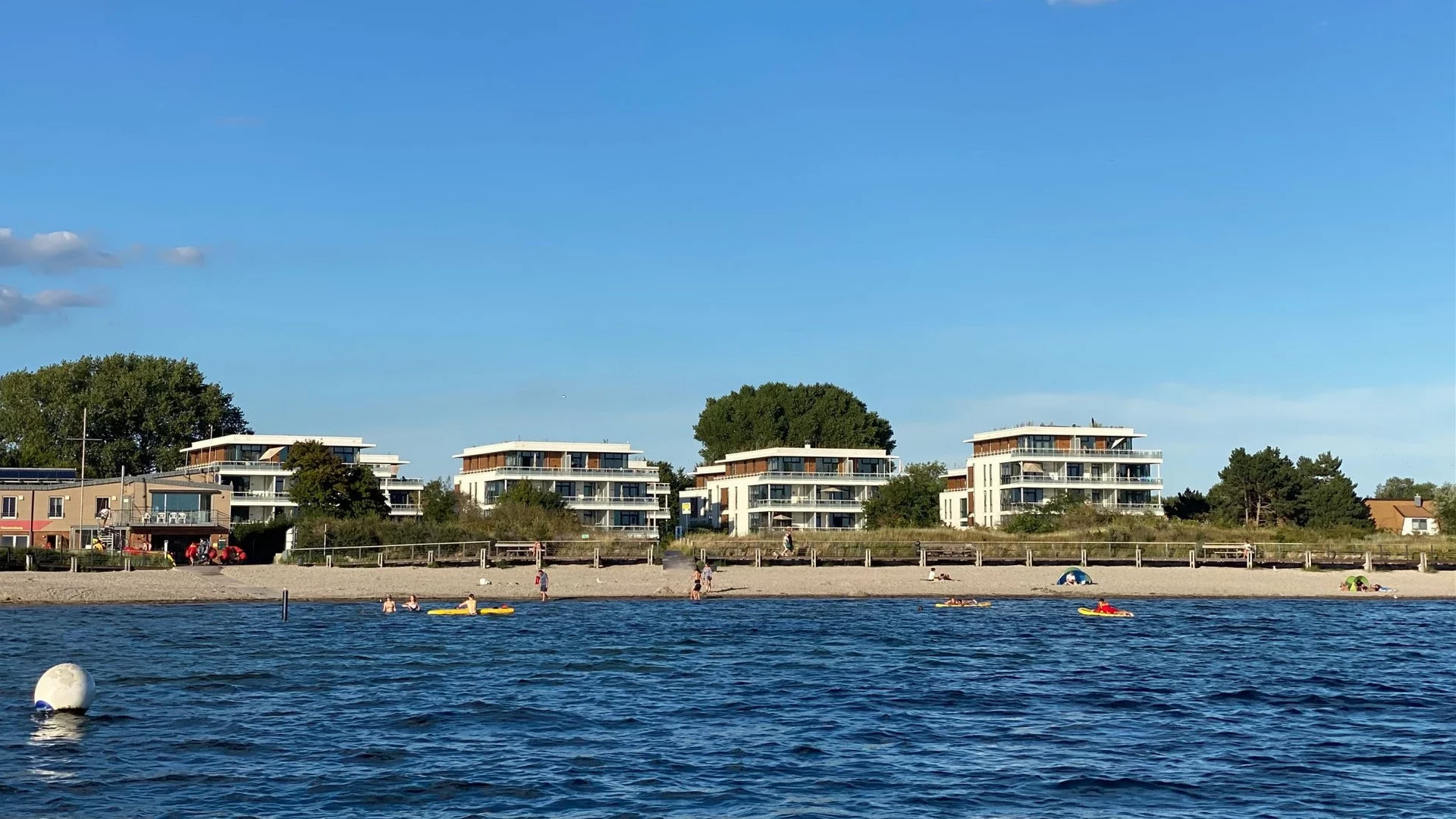 Strand und weiße Ferienhäuser der Anlage Südkap in Pelzerhaken an der Ostsee